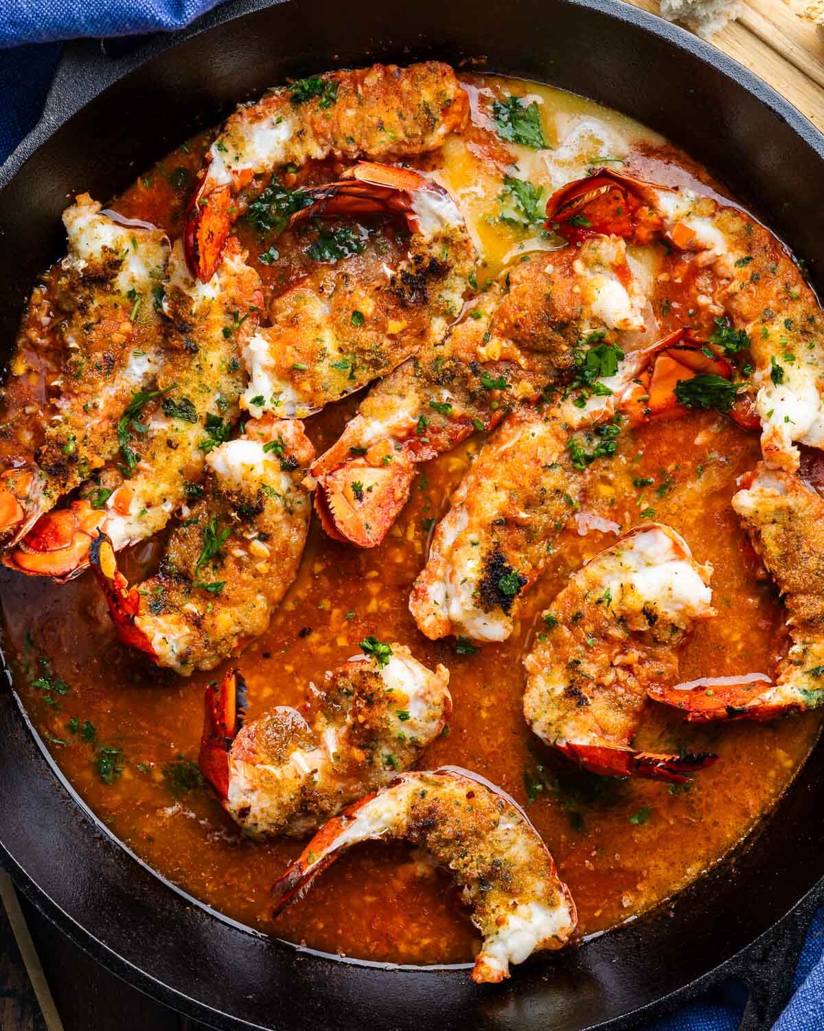Large pan with broiled lobster tails oreganata.