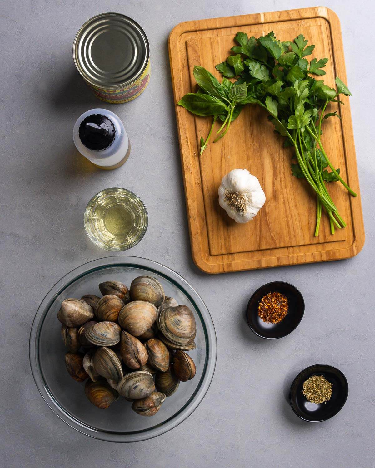 Ingredients shown: plum tomatoes, olive oil, white wine, basil, parsley, garlic, littleneck clams, hot red pepper flakes, and oregano.