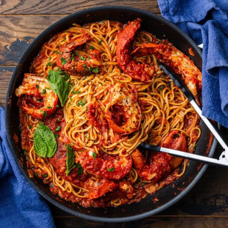 Lobster fra diavolo in black pan with basil garnish.