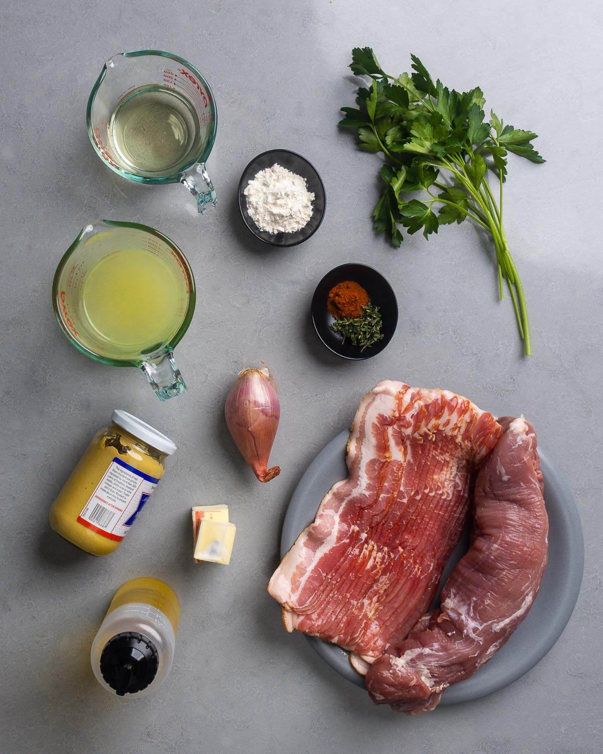 Ingredients shown: wine, flour, parsley, chicken stock, flour, paprika, thyme, shallot, mustard, butter, olive oil, bacon, and pork tenderloin.