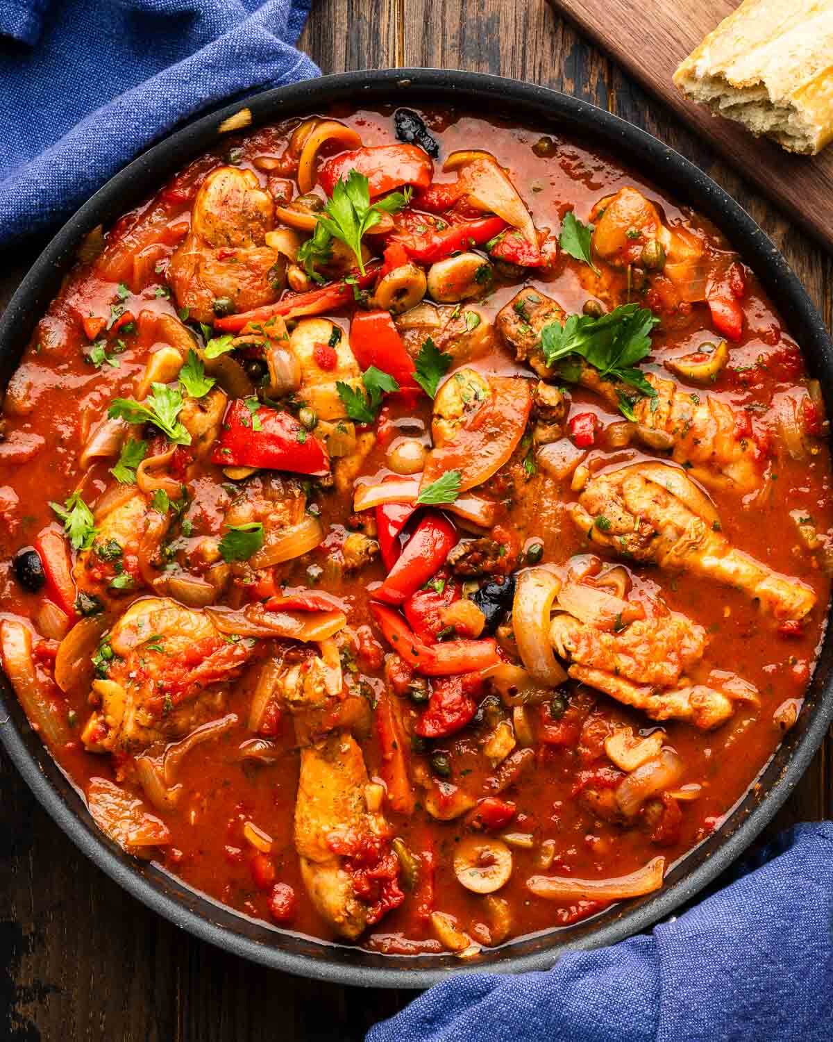 Chicken cacciatore in large black pan.