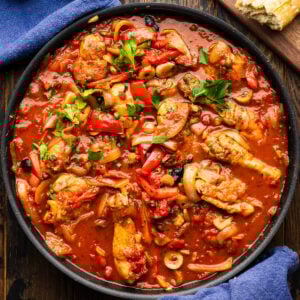 Chicken cacciatore in black pan with side of bread.