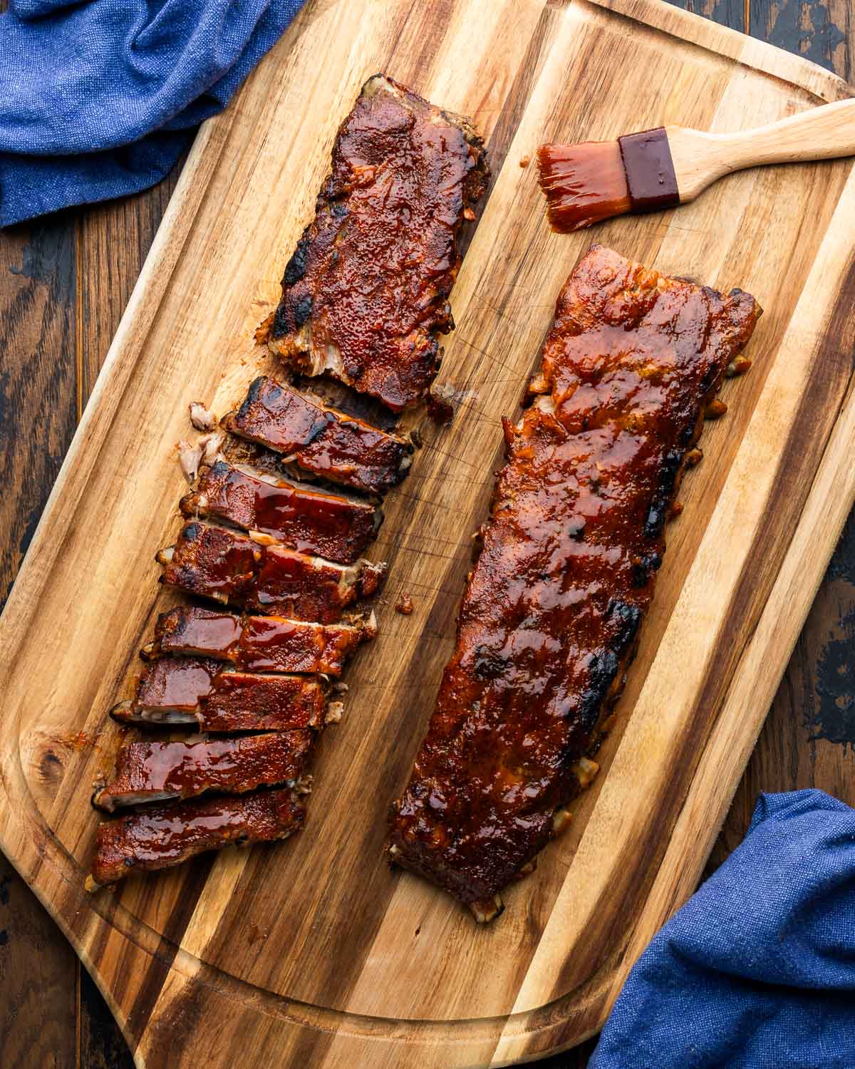 Oven bbq ribs sliced on large cutting board.