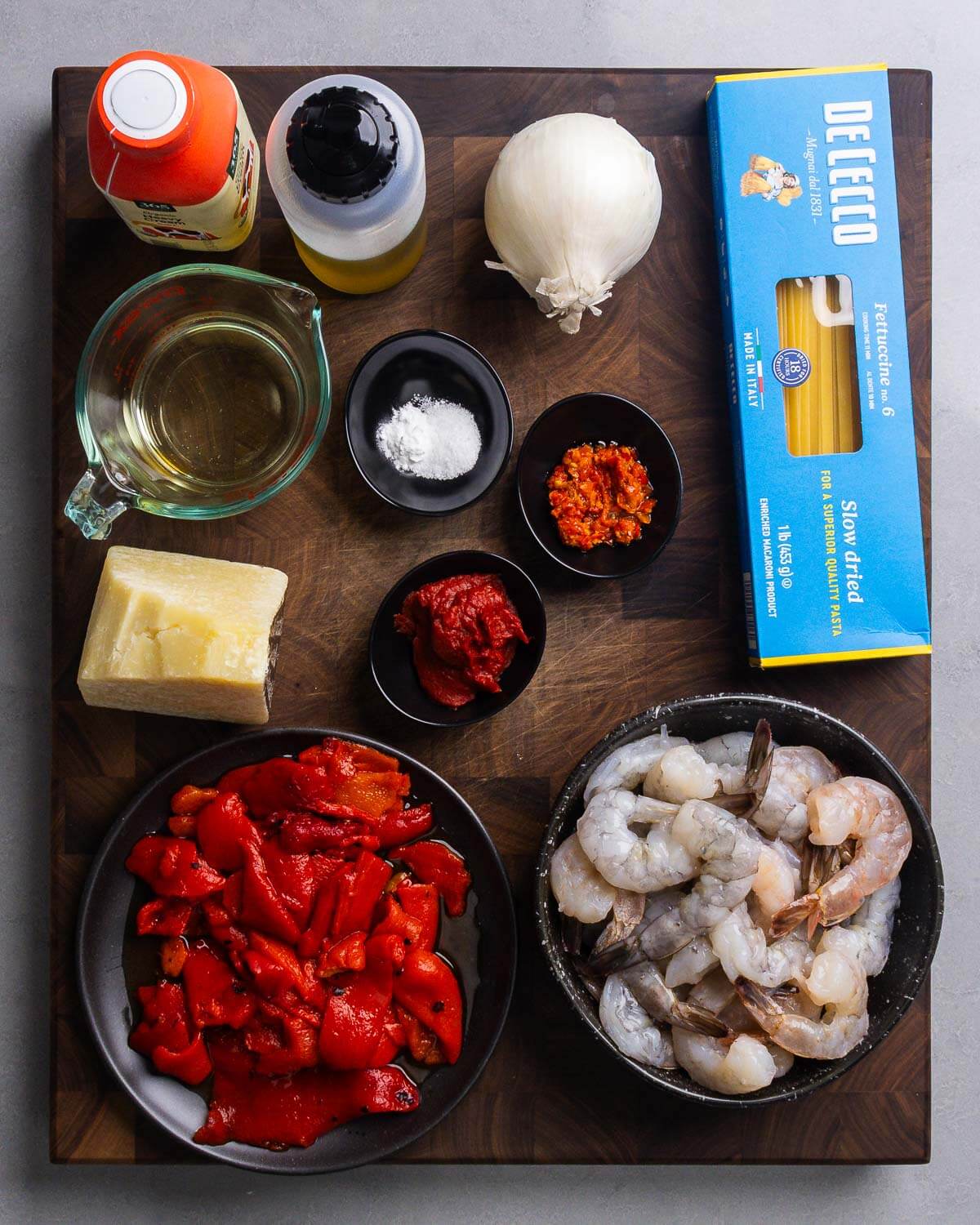 Ingredients shown: cream, olive oil, onion, pasta, wine, baking soda, Calabrian chili paste, tomato paste, Pecorino Romano, roasted red peppers, and shrimp.