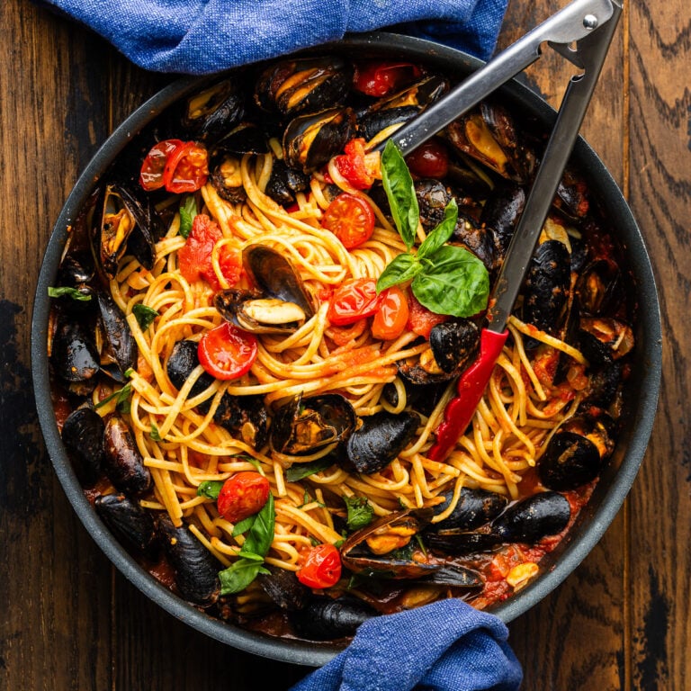 Linguine with mussels in large black pan.