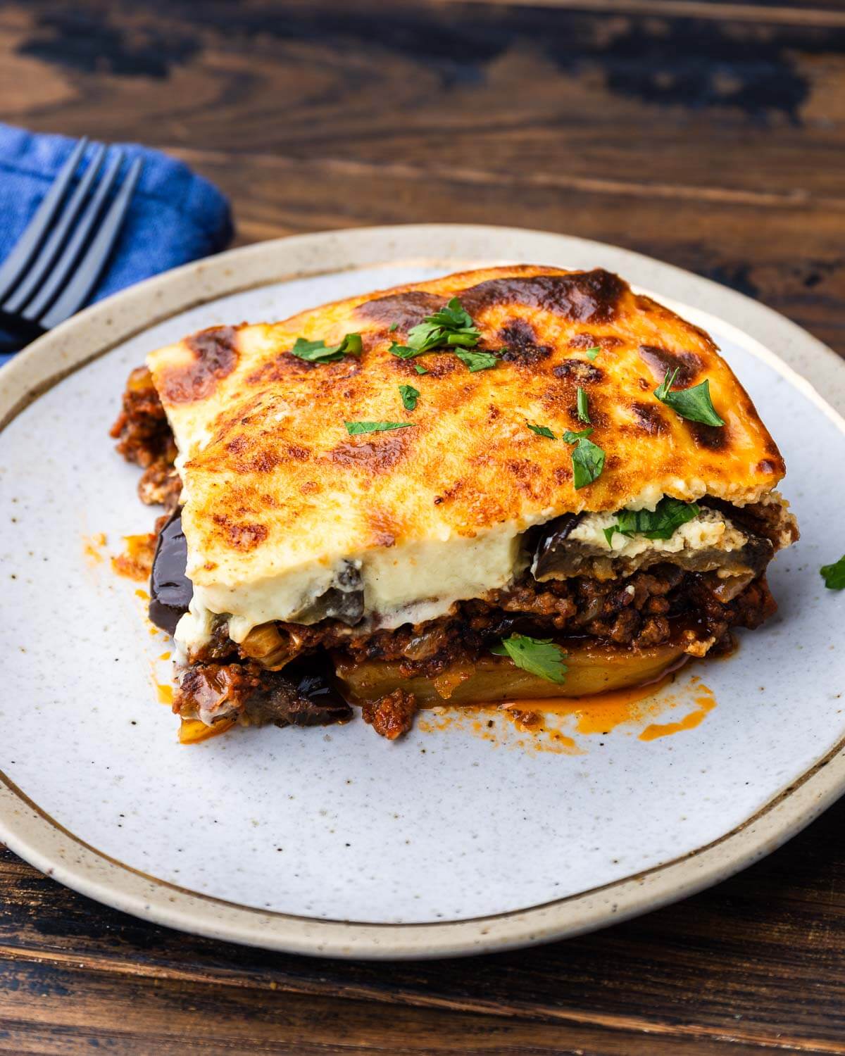 Slice of moussaka on gold plate.