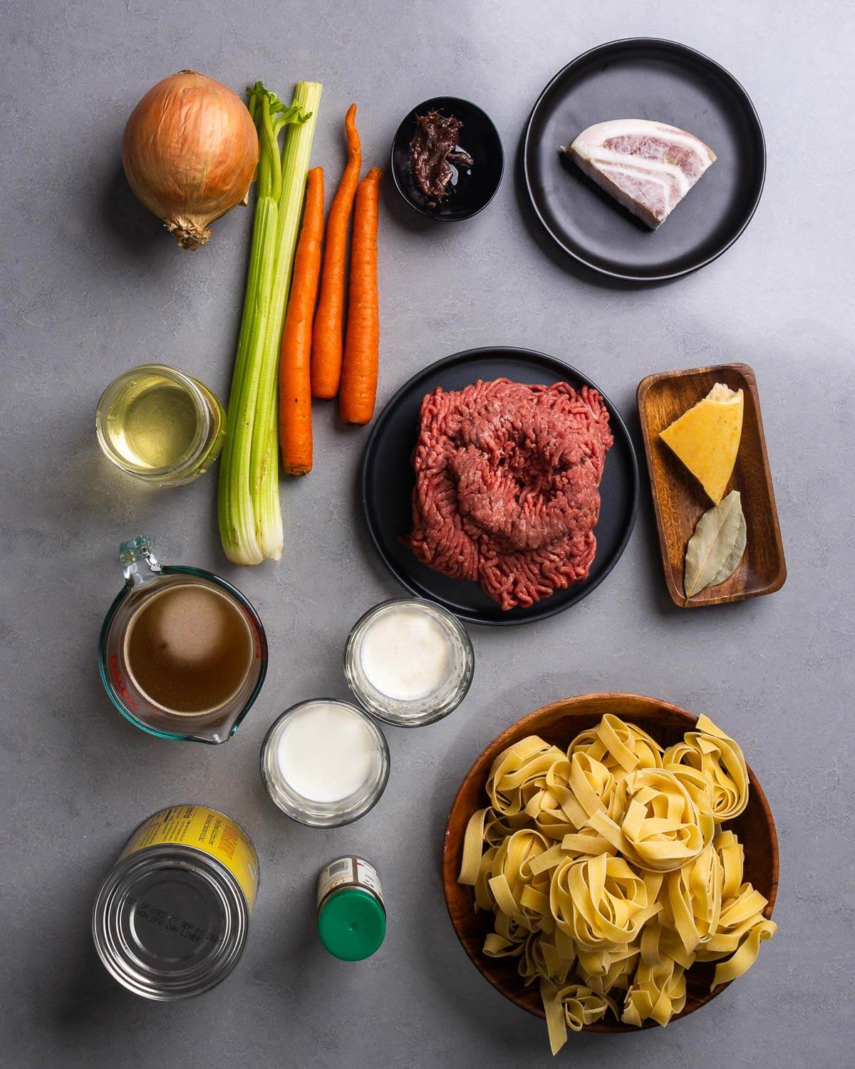 Ingredients shown: onion, celery, carrots, anchovies, pancetta, wine, ground chuck, parmesan rind, bay leaves, beef stock, milk, cream, canned tomatoes, nutmeg, and pappardelle nests.