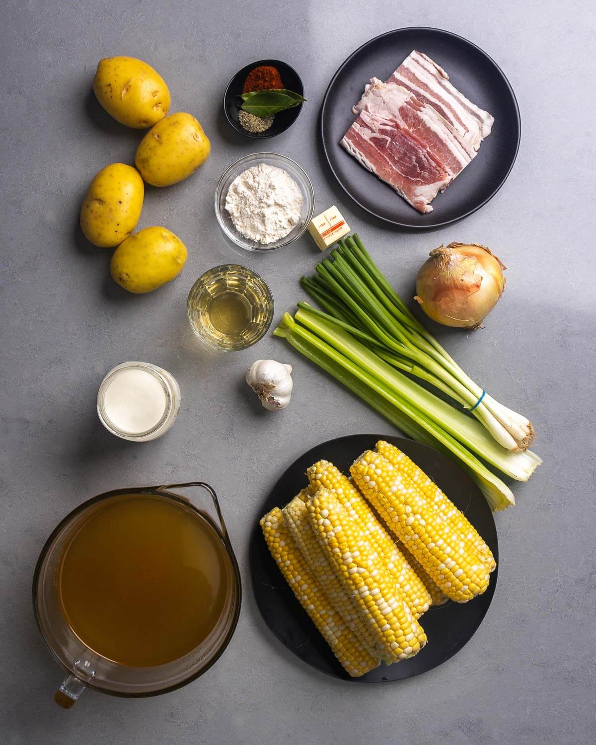 Ingredients shown: potatoes, herbs and spices, bacon, flour, butter, green onions, onion, white wine, garlic, celery, cream, chicken stock, and corn.