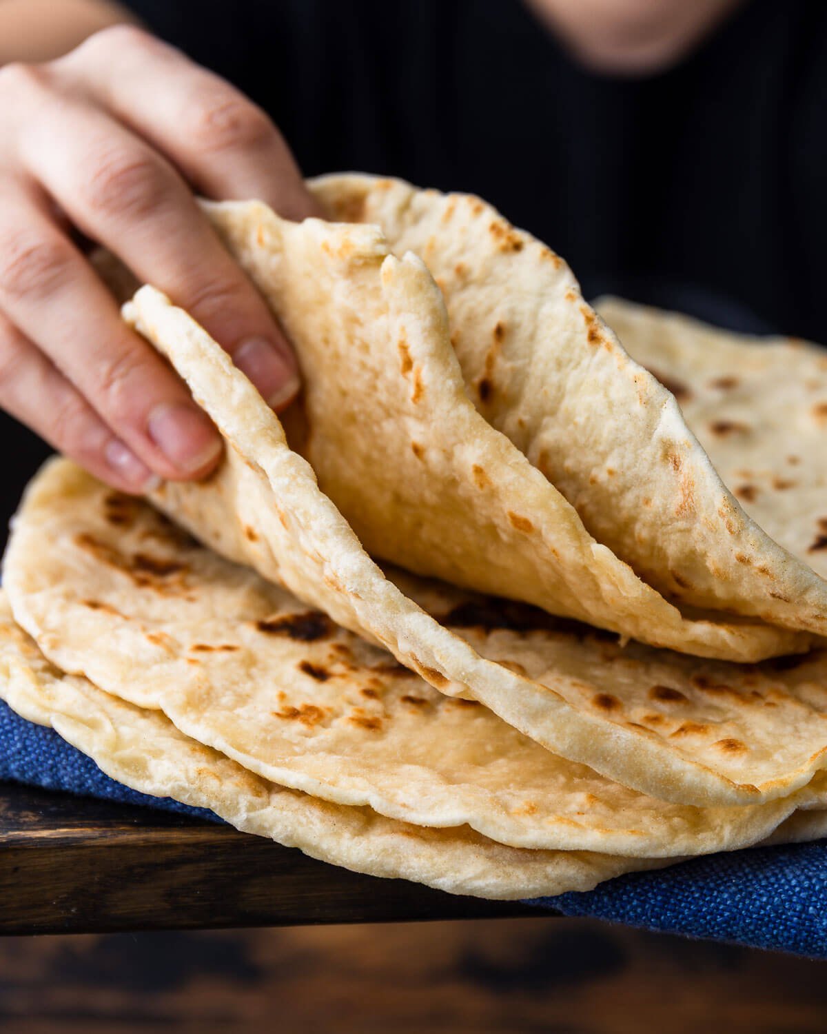 Hands showing a stack of flatbreads.