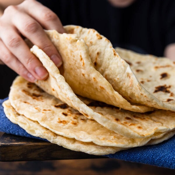 Hands holding flatbreads.