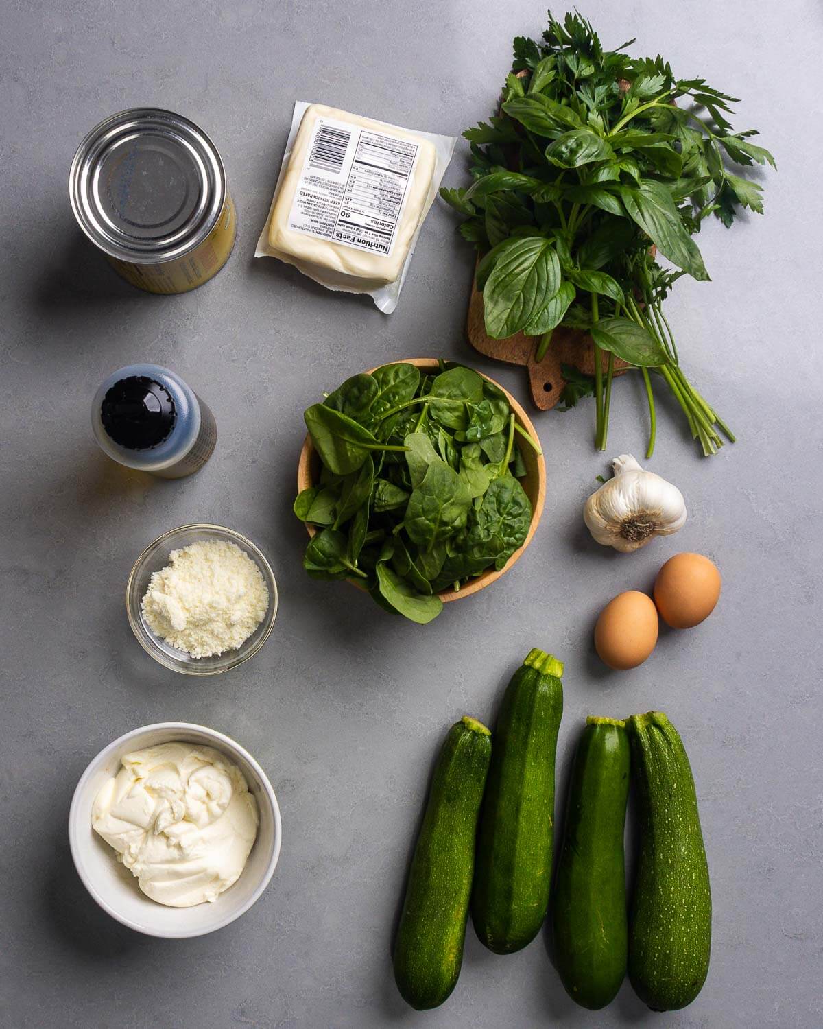 Ingredients shown: tomatoes, mozzarella, basil, parsley, olive oil, spinach, garlic, eggs, pecorino romano, ricotta, and zucchini.