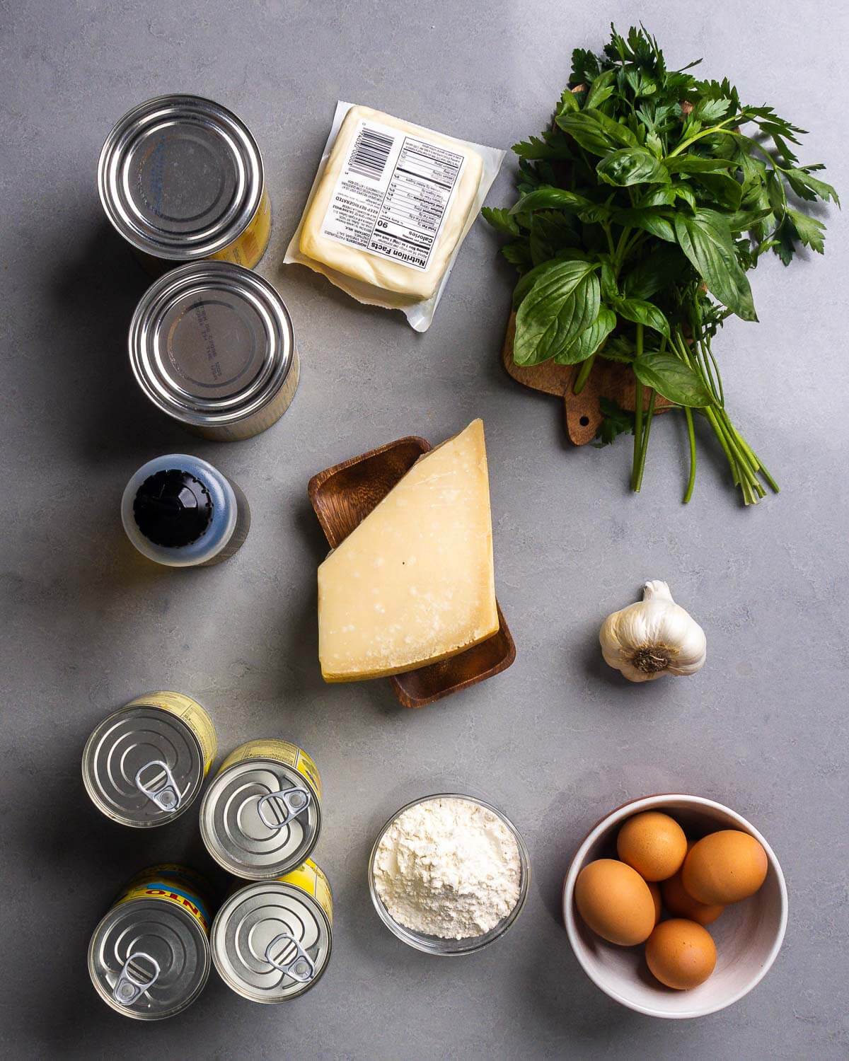 Ingredients shown: canned plum tomatoes, mozzarella, basil, parsley, olive oil, parmesan cheese, garlic, canned artichoke hearts, flour, and eggs.