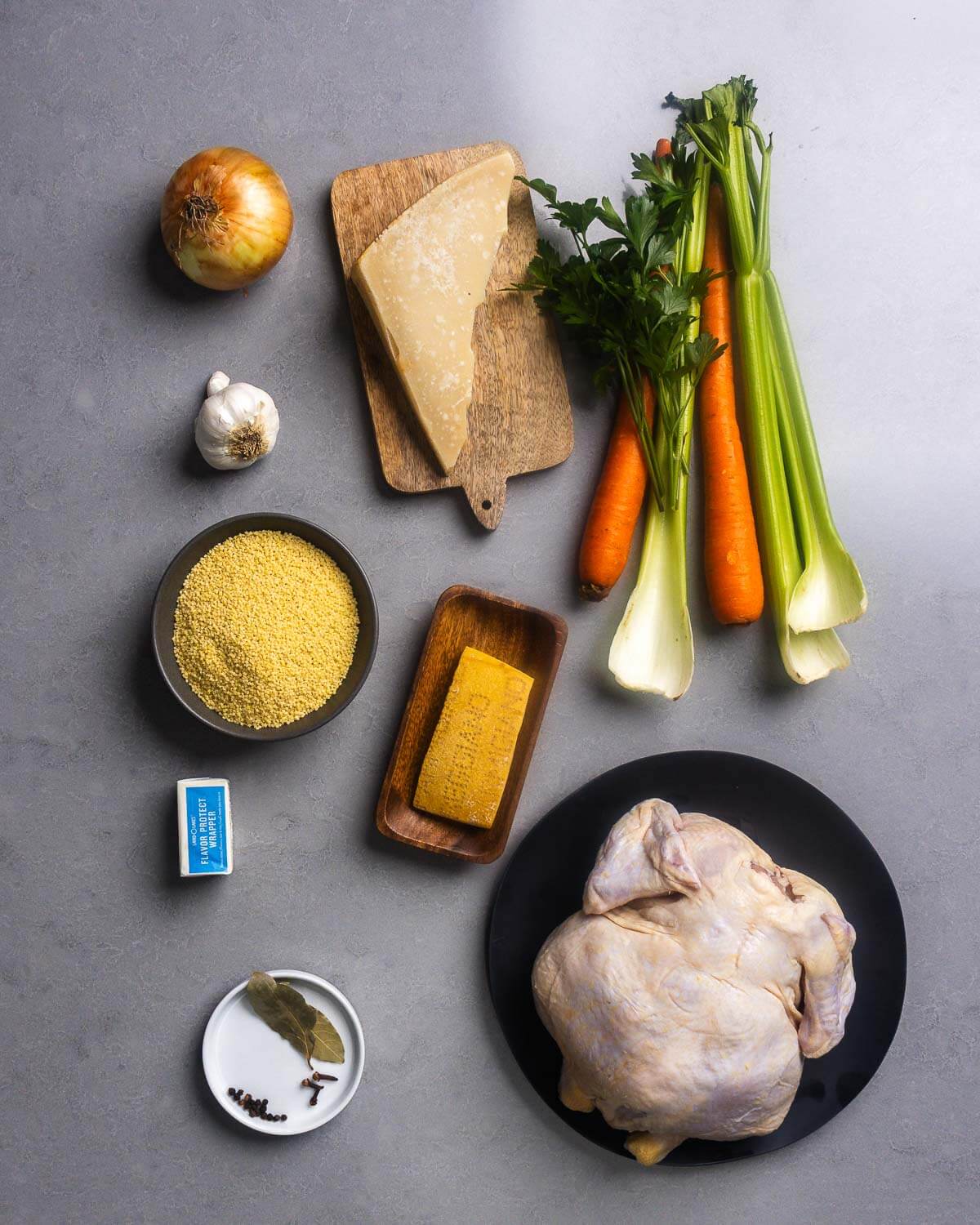 Ingredients shown: onion, Parmigiano Reggiano, parsley, celery, carrot, garlic, pastina, parmesan rind, butter, bay leaves, cloves, peppercorns, and whole chicken.