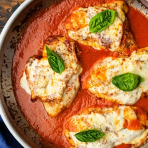 Pan of chicken with prosciutto and cheese in creamy tomato sauce.