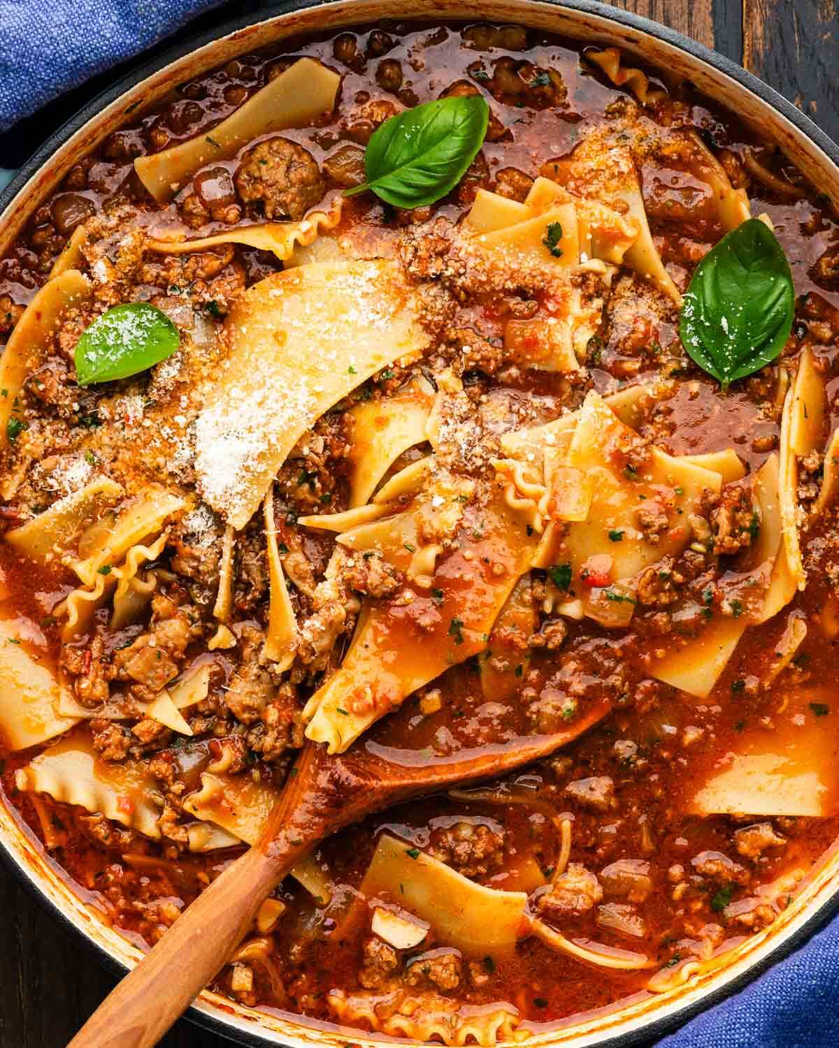 Lasagna soup in large Dutch oven with wooden ladle.