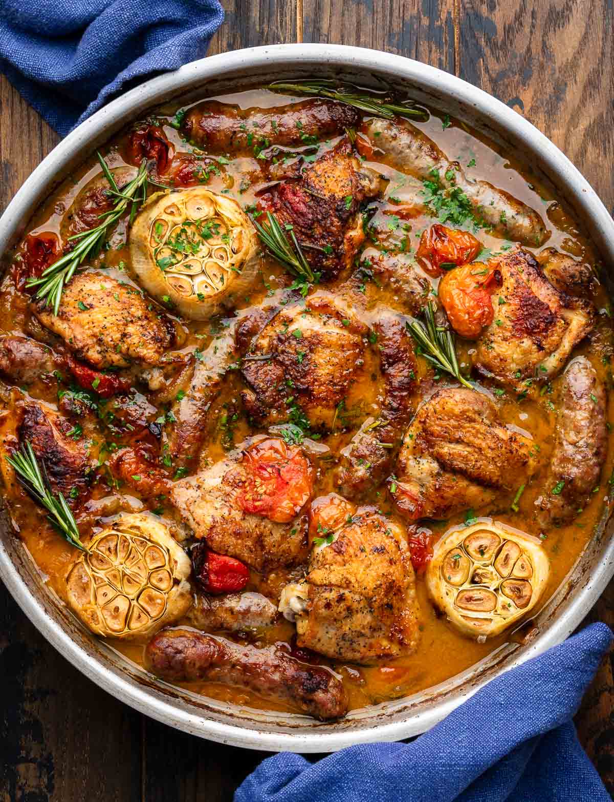Rosemary chicken with sausage and tomatoes in pan.