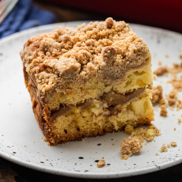 Slice of apple coffee cake on white plate.