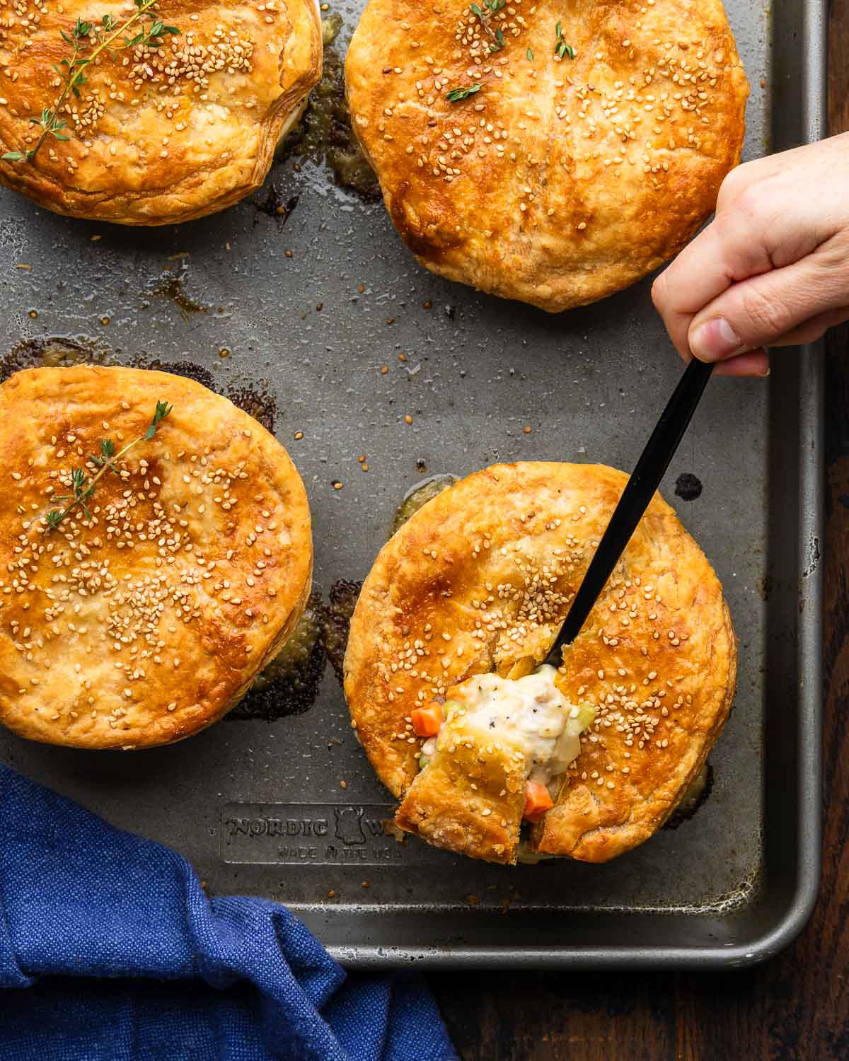 Hand with spoonful of chicken pot pie.