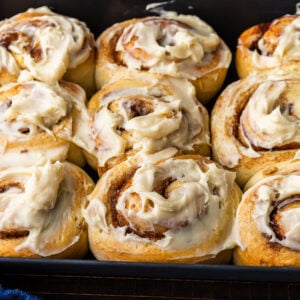 Baking dish with cream cheese frosted cinnamon rolls.