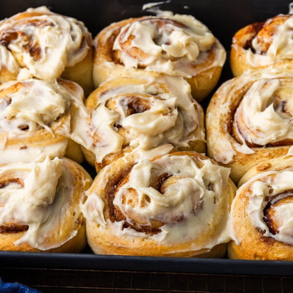 Baking dish with cream cheese frosted cinnamon rolls.