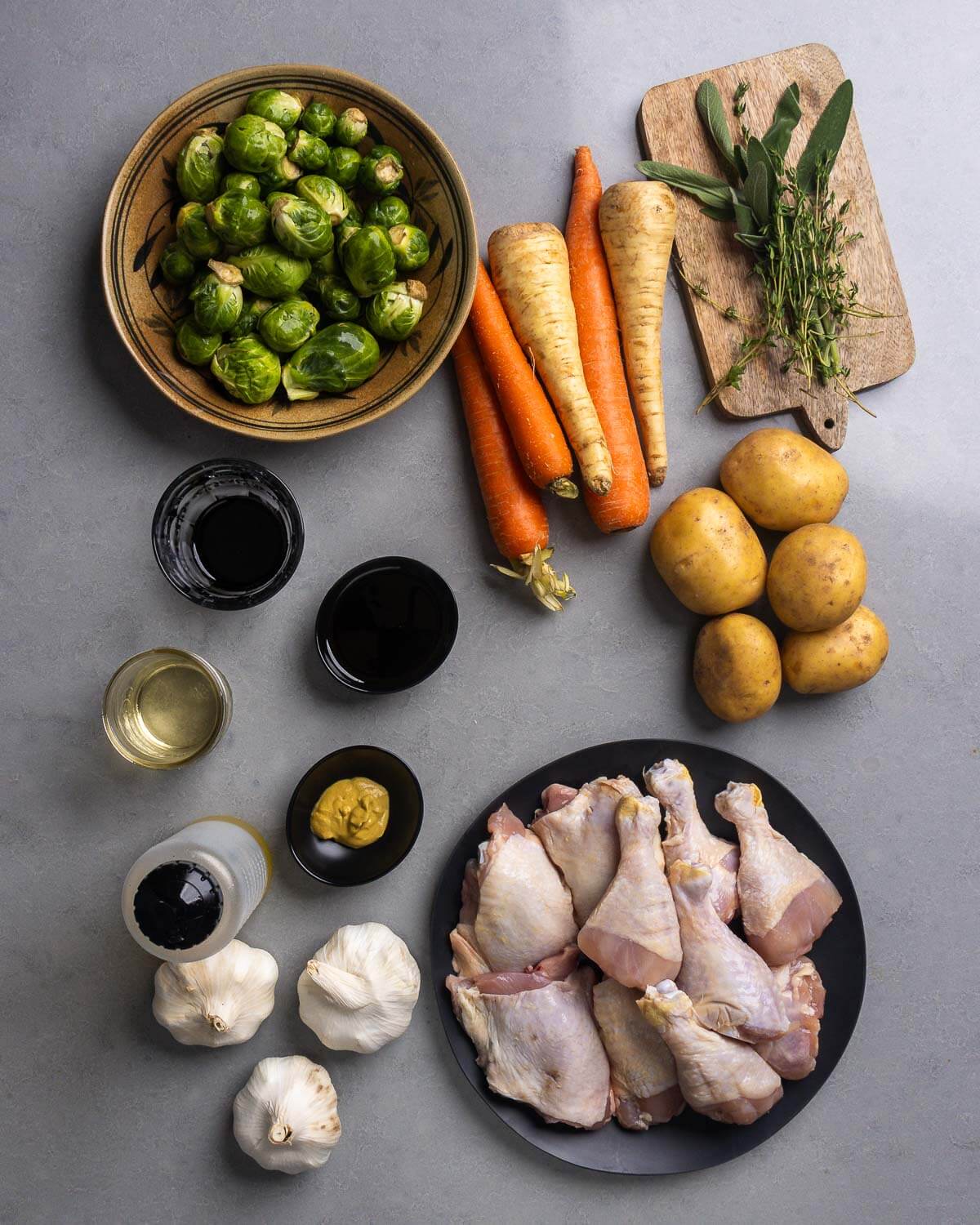 Ingredients shown: brussels sprouts, carrots, parsnips, sage, thyme, potatoes, balsamic vinegar, maple syrup, white wine, mustard, olive oil, garlic, and chicken thighs and legs.