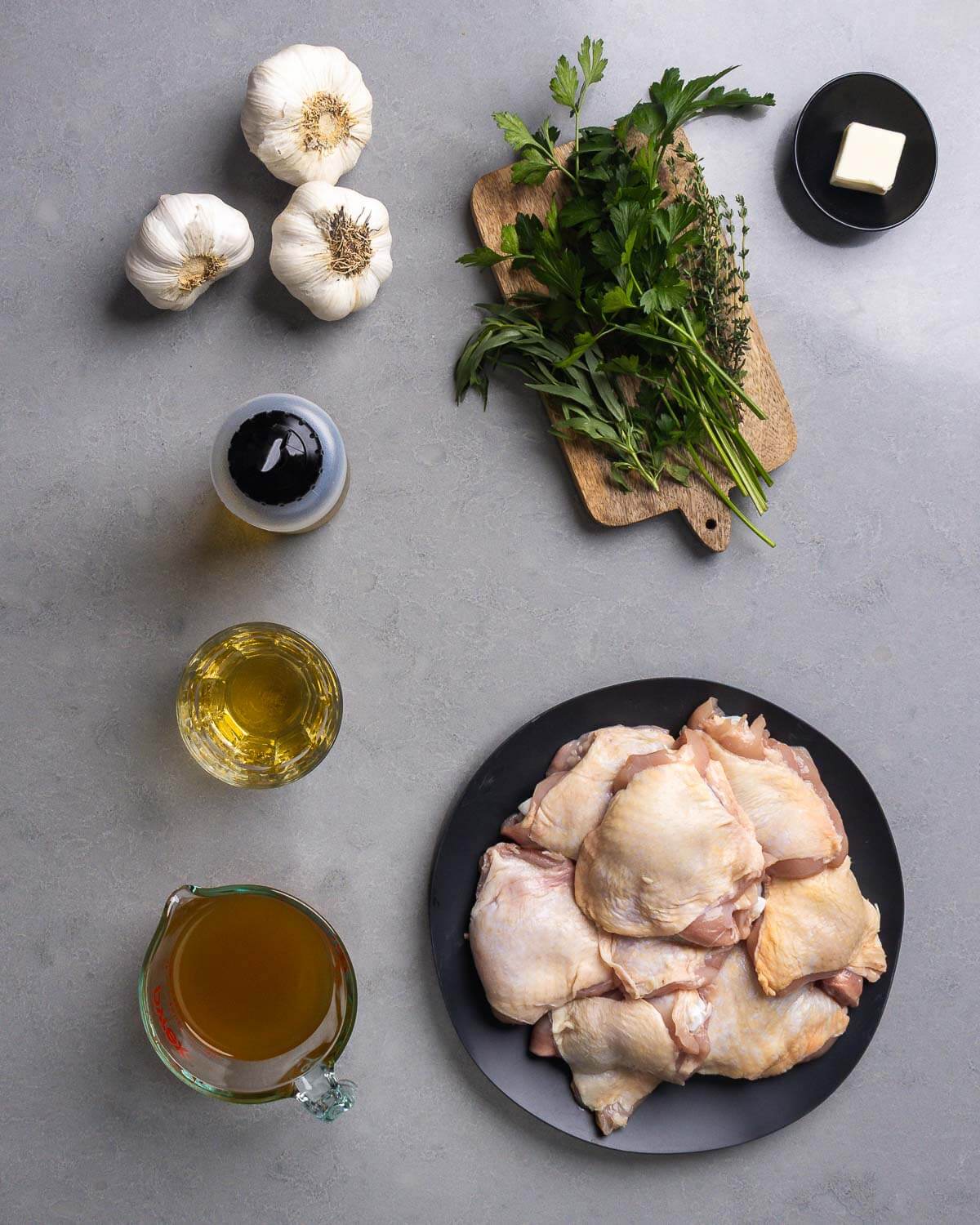 Ingredients shown: garlic, parsley, tarragon, thyme, butter, olive oil, vermouth, chicken stock, and chicken thighs.
