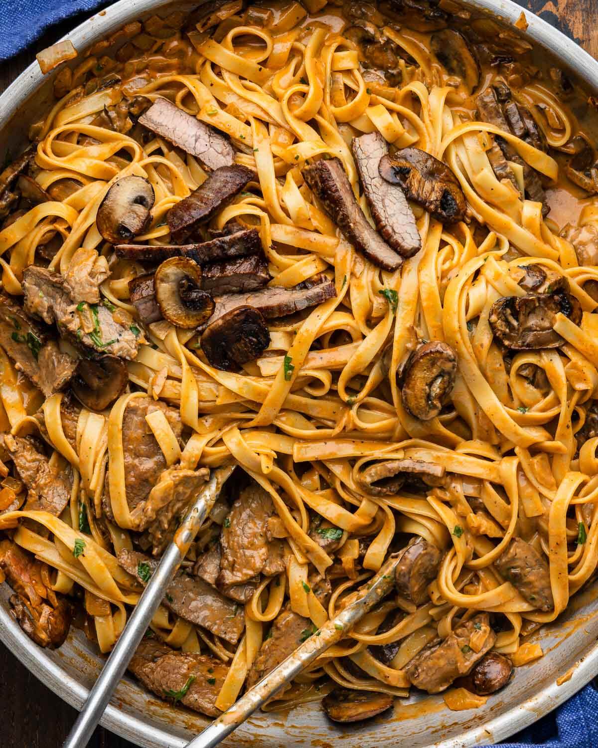 Large pan with bourbon steak and mushroom pasta.