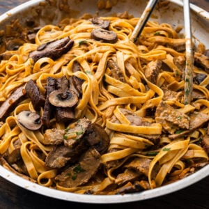 Creamy bourbon steak and mushroom pasta in large pan.