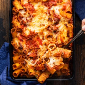 Pasta al forno (baked rigatoni with meat sauce) in black baking dish.