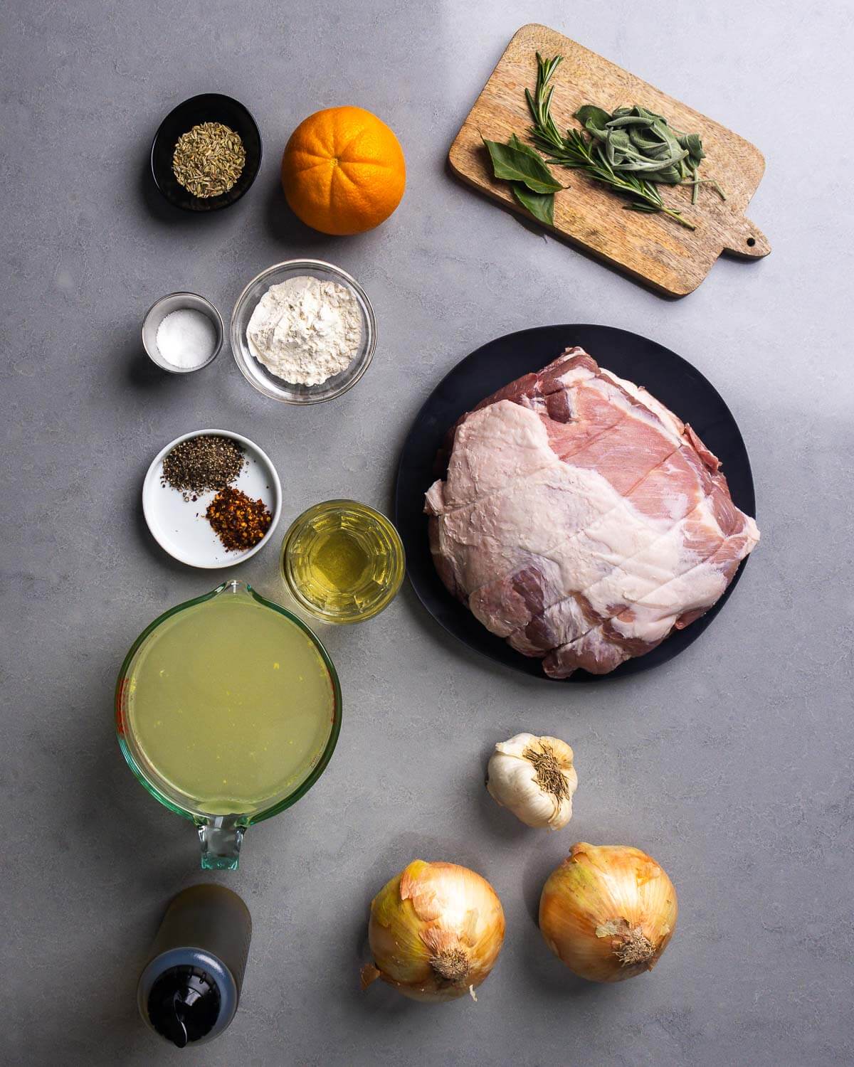 Ingredients shown: fennel seeds, orange, salt, flour, sage, rosemary, pepper, hot red pepper flakes, wine, pork shoulder, chicken stock, garlic, olive oil, and onions.