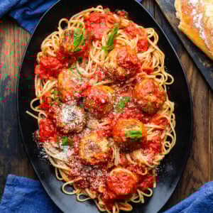 Black platter with chicken meatballs and linguine.