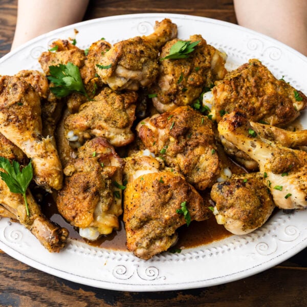 Hands holding platter of chicken savoy.