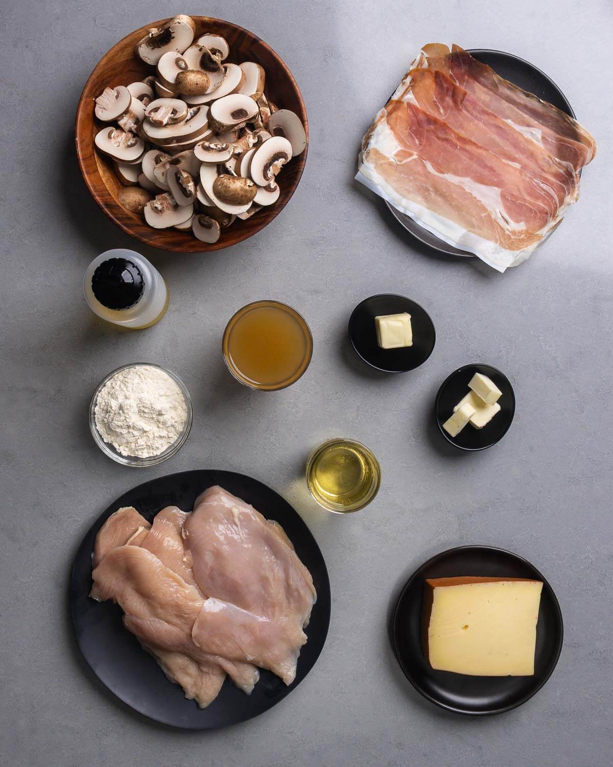 Ingredients shown: mushrooms, prosciutto, olive oil, flour, chicken stock, butter, white wine, chicken cutlets, and Fontina cheese.