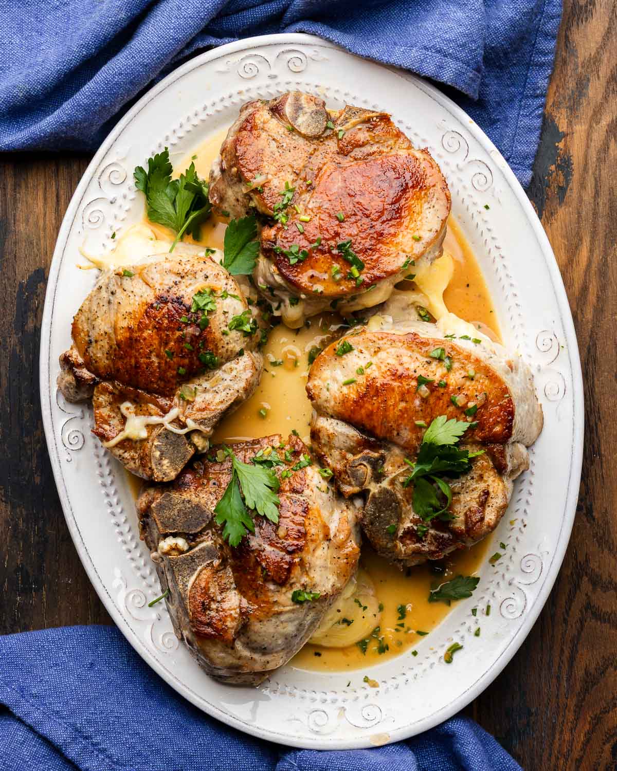 Plate of stuffed pork chops with prosciutto and fontina cheese.