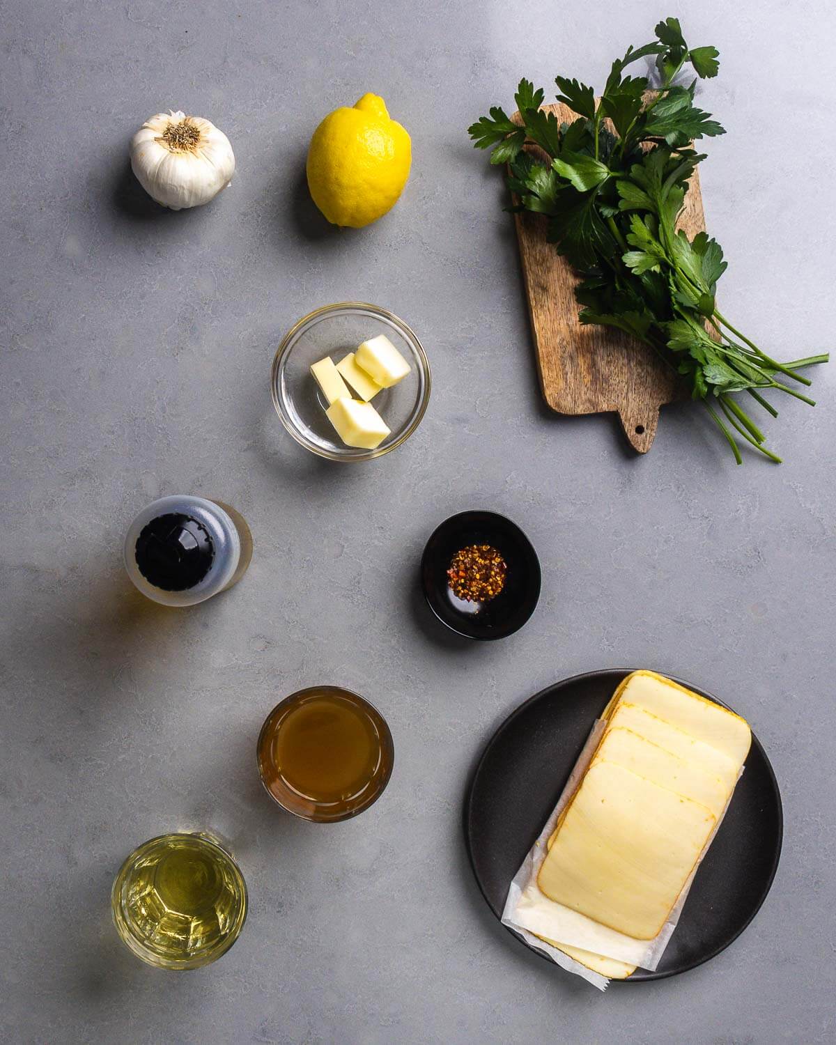 Chicken scampi ingredients shown: garlic, lemon, butter, parsley, olive oil, hot red pepper flakes, chicken stock, white wine, and American muenster cheese.