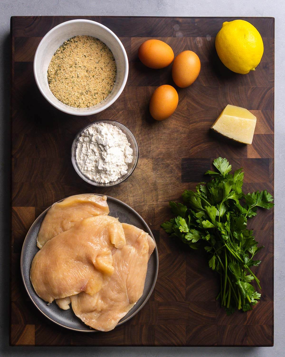 Chicken cutlet ingredients shown: breadcrumbs, eggs, flour, chicken cutlets, and parsley.