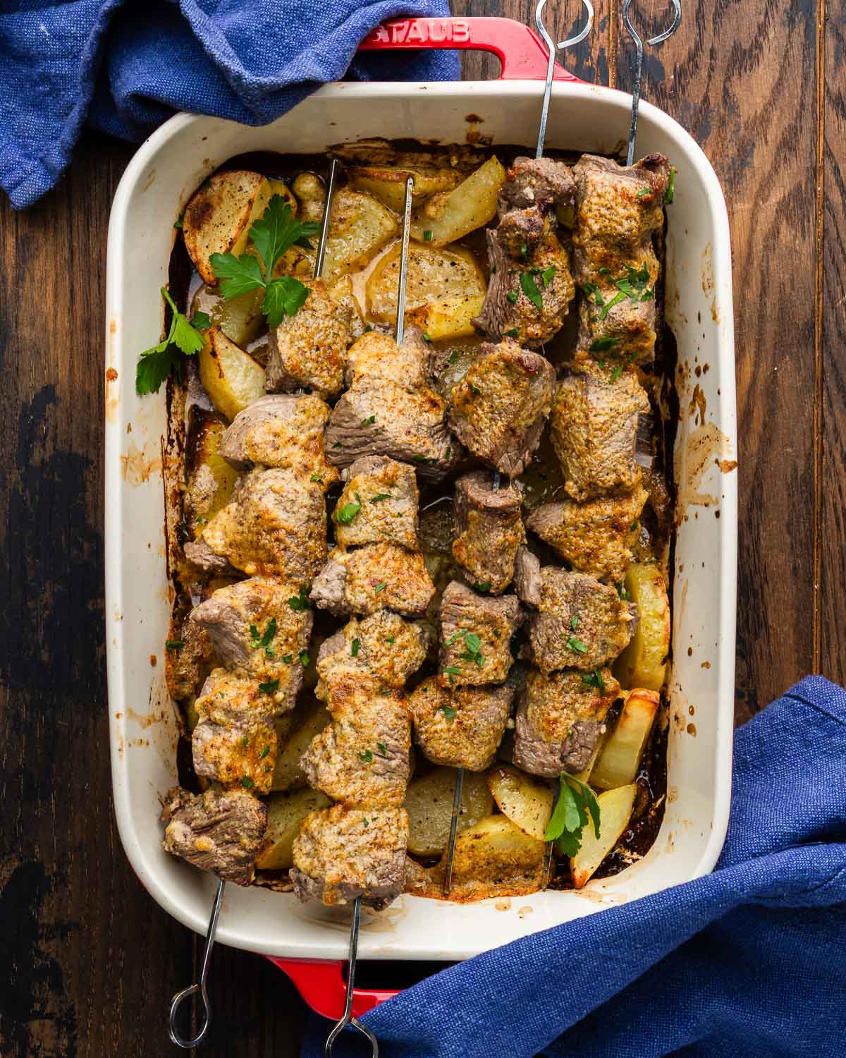 Large baking dish with parmesan steak and potatoes.