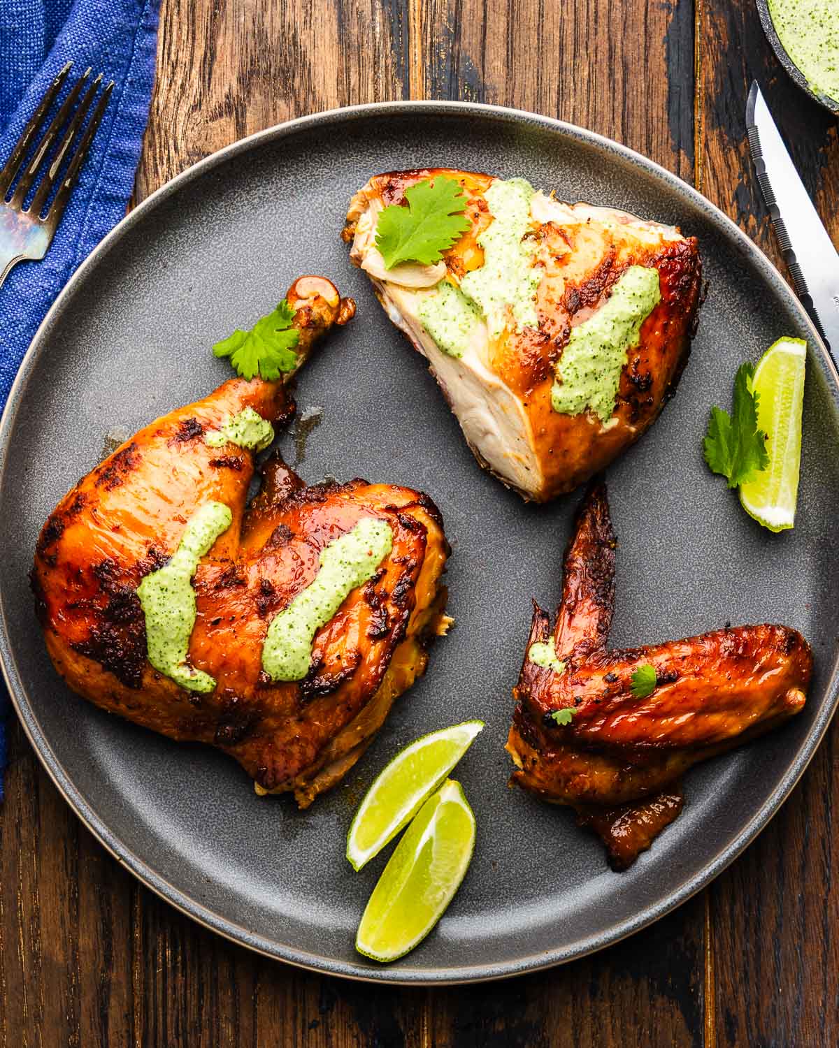Three pieces of Peruvian chicken on grey plate.