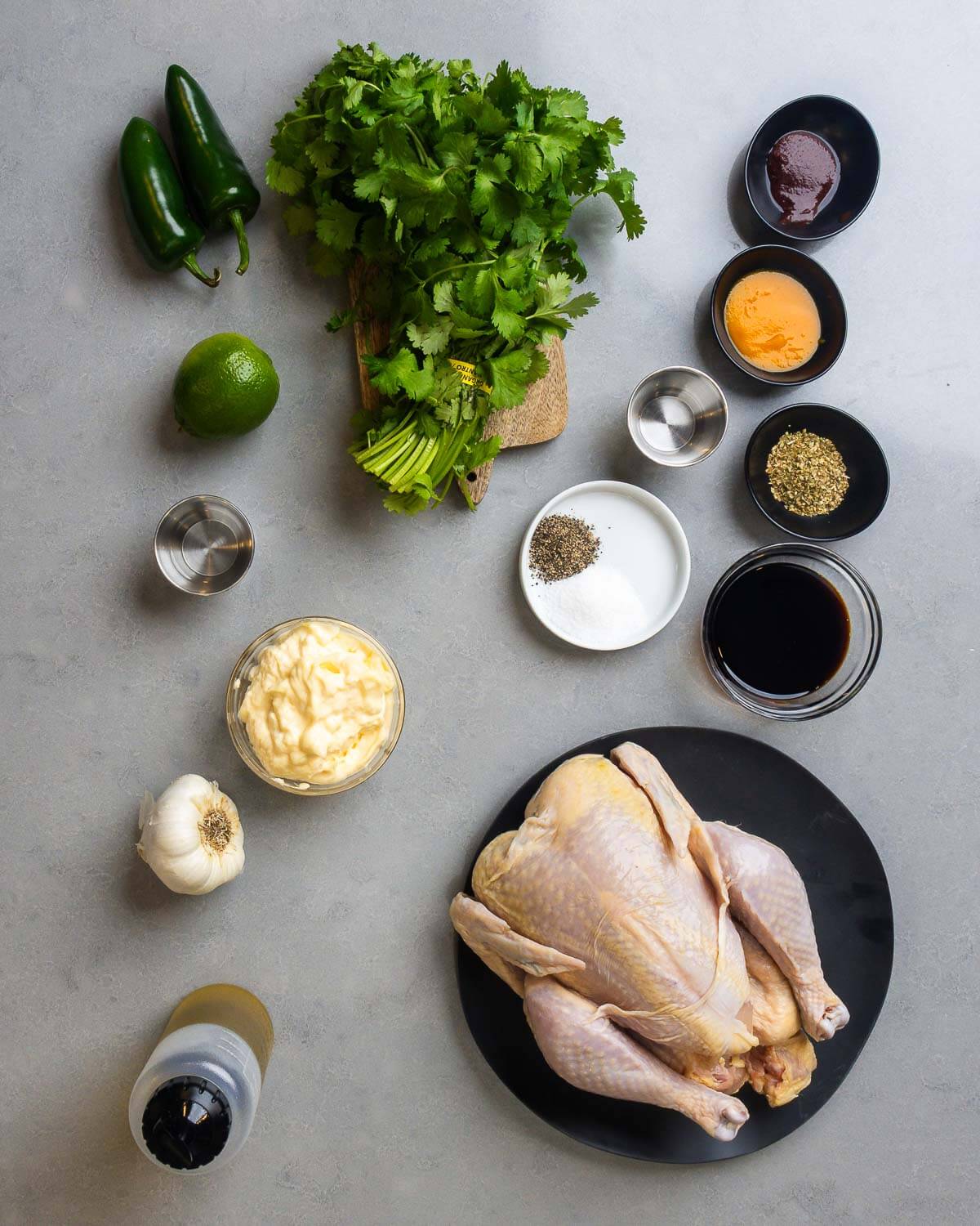 Ingredients shown: jalapenos, cilantro, lime, vinegar, aji amarillo paste, aji panca paste, spices, soy sauce, mayonnaise, garlic, olive oil, and a whole chicken.