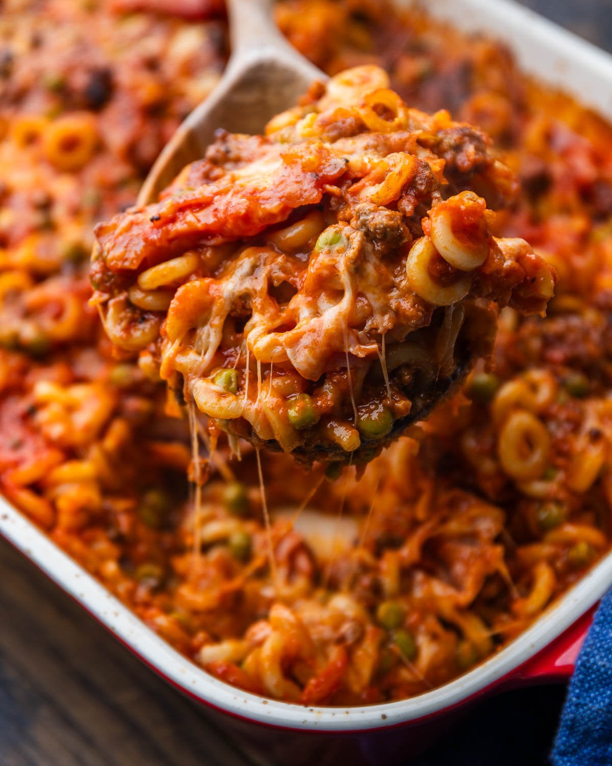 Wooden spoon holding large section of anelletti al forno.