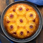 Pineapple upside down cake on grey plate.