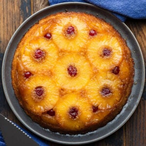 Pineapple upside down cake on grey plate.