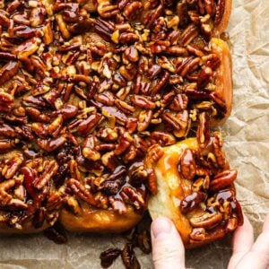 Hands grabbing a sticky bun.