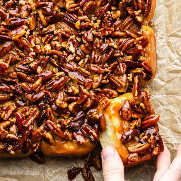 Hands grabbing a sticky bun.