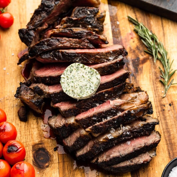 Sliced grilled tomahawk steak topped with compound butter.