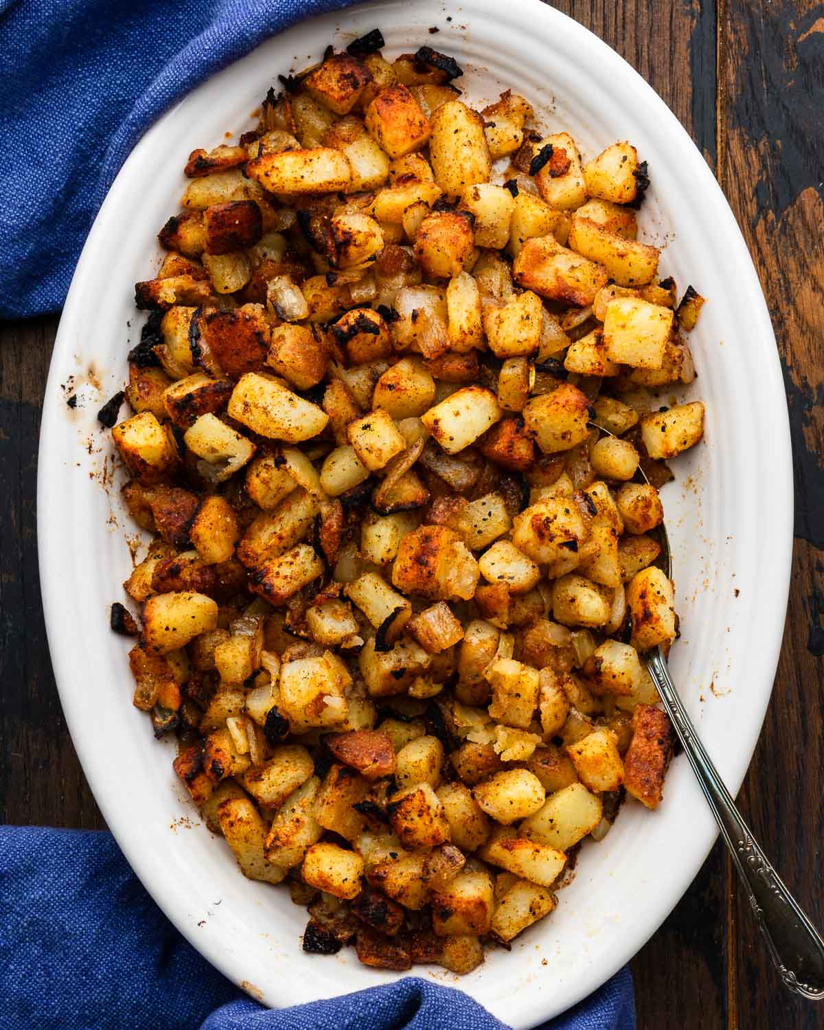 Steakhouse homefries in white platter.