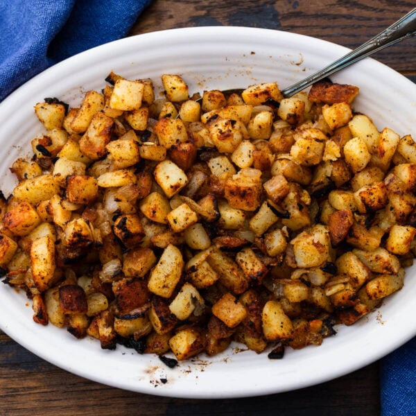 Steakhouse homefries in white platter.
