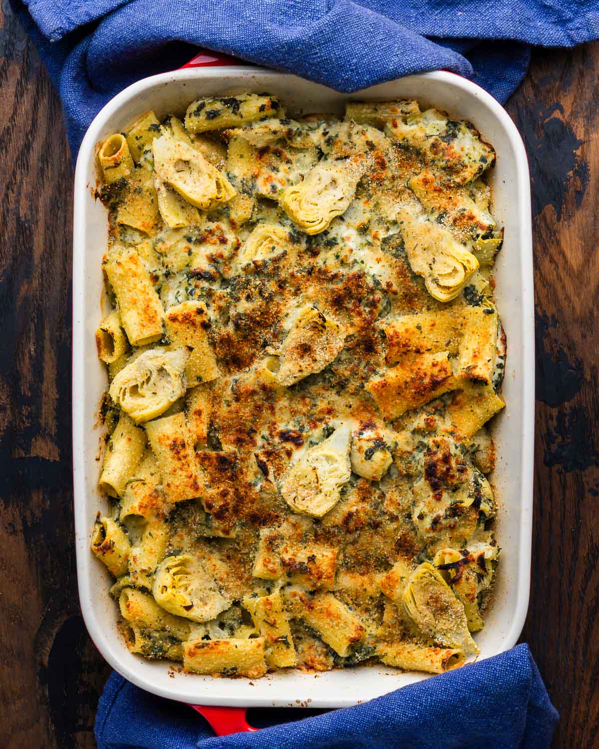 Baked artichoke and spinach pasta in large baking dish.