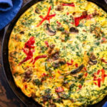 Sausage, mushroom, and roasted red pepper frittata in cast iron pan.