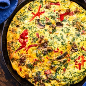 Sausage, mushroom, and roasted red pepper frittata in cast iron pan.